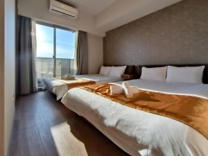大阪Ostay Vermillion Namba的配有大窗户的酒店客房内的两张床