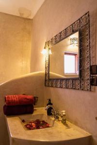 马拉喀什Riad Sérénis的浴室设有水槽和墙上的镜子