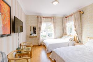 阿普春安BACH TÙNG Garden Village的一间卧室设有两张床和窗户。