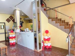 安吉利斯Jun and Helen Hotel and Restaurant的大堂设有多彩气球的楼梯