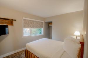 坎卢普斯Scott's Inn & Suites的卧室配有白色的床和窗户。