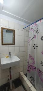 阿皮亚Lynn's Getaway Hotel的一间带水槽和淋浴帘的浴室