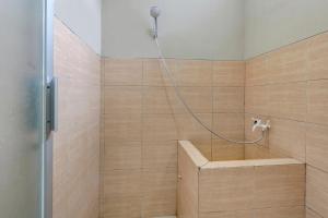 TuntangOYO Life 90159 Puri Asoka Guest House的带淋浴的浴室和长凳