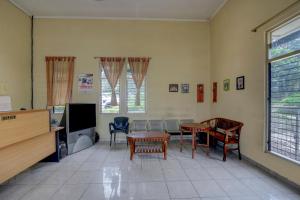 TuntangOYO Life 90159 Puri Asoka Guest House的客厅配有桌椅和电视。