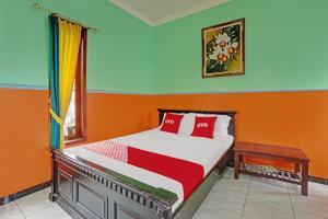 巴图OYO Life 90321 Ken Ken Villa的一间卧室配有橙色和蓝色墙壁的床