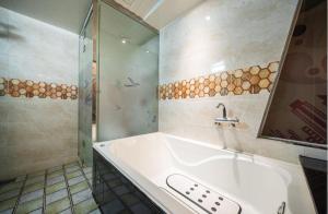 蔚山Hotel Kobos的带浴缸、淋浴和盥洗盆的浴室
