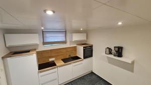 达姆施塔特Handwerkerwohnung-Monteurunterkunft的小厨房配有白色橱柜和水槽