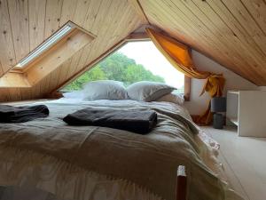 惠特比The Cabin at Shambala- now with sauna available to book!的一张大床,位于带大窗户的房间里