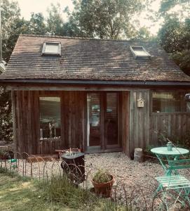 惠特比The Cabin at Shambala- now with sauna available to book!的一座带桌子和窗户的小木房子