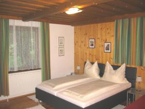 隆高地区圣玛格丽滕施瓦格膳食酒店的卧室在窗户前配有一张大床