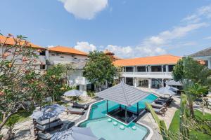 库塔Casa Wina Kuta的享有酒店高空的景致,设有游泳池、椅子和遮阳伞