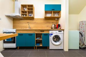 普罗夫迪夫Modern 1BR Apartment with Private Garden Top Center的厨房配有蓝色橱柜和洗衣机。