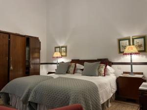 大加那利岛拉斯帕尔马斯Casa Colonial El Indiano的一间卧室配有一张大床和两盏灯