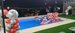 Yarkaסוויטה בכפר ירכא的游泳池旁的一大堆红白气球