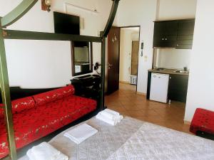 基尼拉蓝湾海滩酒店的一间带红色沙发的客厅和一间厨房