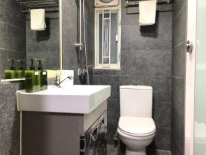 香港香港名都商务旅馆 self-check-in的一间带卫生间、水槽和镜子的浴室
