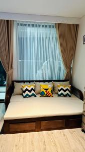 绥和市Apec Mandala Phú Yên View Biển的窗户前的一张带枕头的床