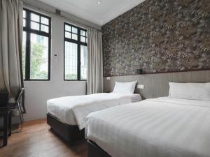 新加坡Noble Hotel的酒店客房带两张床和两个窗户