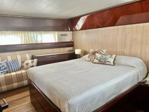巴塞罗那MotorYacht 21 avec équipage的船上的卧室,配有床和沙发