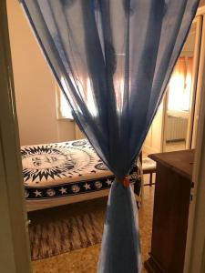 卡斯蒂里昂纳·德拉佩Appartamento incantevole a 100mt dal mare的一张蓝色窗帘的床