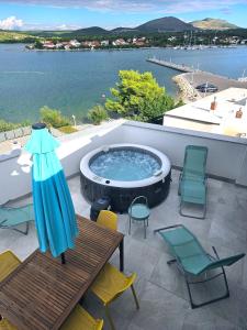 比利切Apartments Picikato的庭院设有热水浴池、椅子和桌子