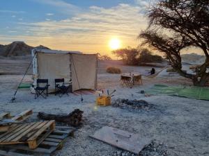 Sappirג'וני- חוויה בקארוון מדברי的沙漠中的帐篷,配有桌椅