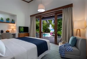 鲁阿环礁Ifuru Island Resort Maldives - 24-Hours Premium All-inclusive with Free Domestic Transfer的一间卧室设有一张床和一个滑动玻璃门