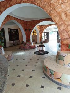 阿布辛贝Hllol Hotel Abu Simbel的大堂设有石墙和瓷砖地板。