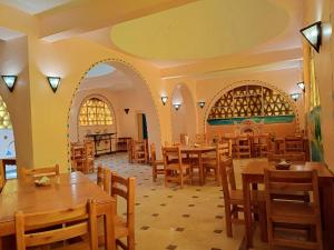 阿布辛贝Hllol Hotel Abu Simbel的一间在房间内配有桌椅的餐厅