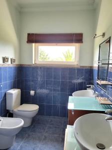 托马尔Sunshine moradia for 10 persons的一间带卫生间和两个盥洗盆的浴室以及窗户。