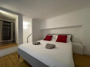 米兰Navigli Design Loft - 7 stops from Duomo, AC, Netflix的卧室配有带红色枕头的大型白色床