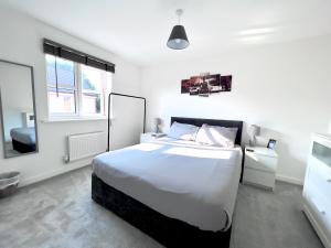 Mile EndNorth Colchester Homestay的白色卧室设有一张大床和两个窗户