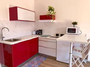 塔瓦伊瓦Las Vistas-Rincón acogedor con vistas al mar的一间设有红色和白色橱柜的小厨房