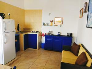 波多诺伏Casa Branca的厨房配有蓝色橱柜和白色冰箱