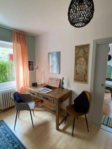 阿斯科纳Accogliente appartamento con cucina arredata的客房设有书桌、两把椅子和窗户。