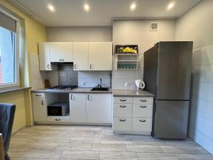 克罗托申Apartament COMFORT Centrum的厨房配有白色橱柜和冰箱。