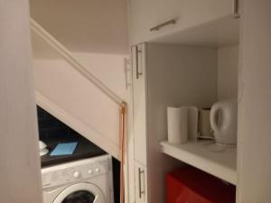 纽波特Cosy 2 Bedroom Flat Newport的一间带洗衣机和楼梯的小厨房