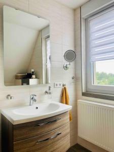 路德斯塔德·威特比Pool, Sauna und Blick ins Grüne的一间带水槽和镜子的浴室以及窗户。