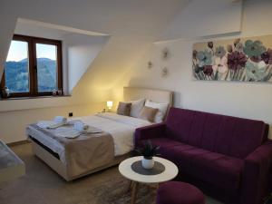 科帕奥尼克Kloudscape Apartman Milmari Resort & Spa的一间卧室配有一张床和一张紫色沙发
