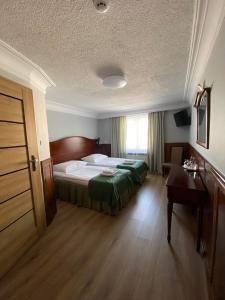 科宁Hotel Kresowianka的配有一张床和一张书桌的酒店客房