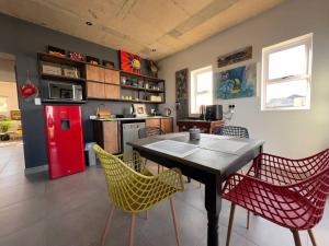 莫塞尔湾Vincent - Artistic Luxury Suite的厨房配有桌椅和红色冰箱。