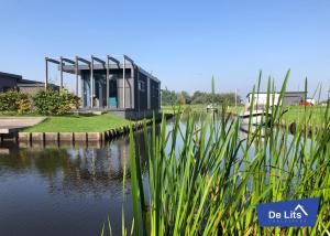 OostermeerChaletpark de Lits的水体上座的建筑物