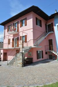 莱维科特尔梅Appartamenti Nadalini的粉红色的建筑,一侧设有楼梯