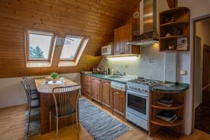 克尔诺夫伊娃克尔诺夫旅馆的厨房配有木制橱柜、炉灶和桌子。