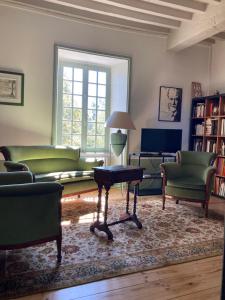 Les Tourellières的客厅配有绿色家具和桌子