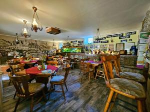 ColditzPension Zur Kutscherstube的一间带木桌椅的餐厅和一间酒吧