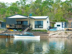 Lake BennettBungalow 58 Lake Bennett Darwin的水面上的房子,前面有船