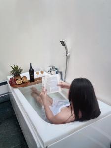 Cái RăngMIHA Villa的躺在浴缸里读书的女人
