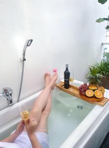 Cái RăngMIHA Villa的女人躺在浴缸里,喝杯酒