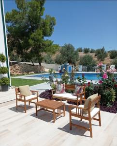 Lefke-KaradağDervise Mehmet Guest House的一个带桌椅的庭院和一个游泳池